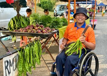 SHARULZILA Sazali menunjukkan manggis dan petai yang dijualnya di Tapak Pasar Tani Kuala Pilah, Negeri Sembilan. - UTUSAN/ NOR SHAFIQAH MOHD. GHAZALI