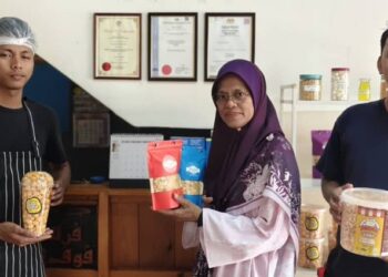 ZALEHA Yusof (tengah) bergambar bersama kakitangan Persada Pop Corn di premis perniagaannya di Banting, Selangor. - UTUSAN/ABDUL RAZAK IDRIS