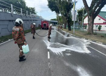 BEBERAPA anggota bomba sedang membersihkan kesan tumpahan minyak diesel di Jalan Masjid Negeri, Pulau Pinang, hari ini.-GAMBAR/JBPM PULAU PINANG