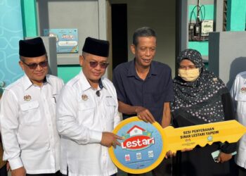 TAHIR (dua dari kanan) menerima replika kunci yang disampaikan oleh Mohd Na’im (dua dari kiri) di Penaga, Kepala Batas, Pulau Pinang hari ini.-UTUSAN/SITI NUR MAS ERAH AMRAN