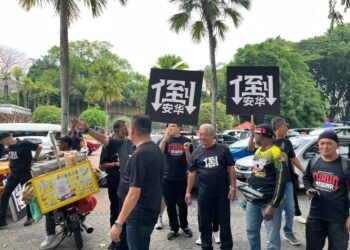 PESERTA perhimpunan membawa sepanduk tulisan bahasa Cina di pekarangan Masjid Negara, Kuala Lumpur, hari ini.