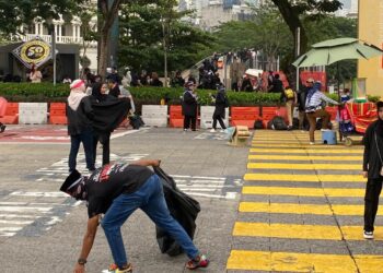 SEORANG peserta Himpunan Turun Anwar mengutip sampah sarap di Dataran Merdeka, Kuala Lumpur.