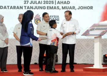 ANWAR Ibrahim menerima blok konsol ‘Rakyat di Santuni’ daripada seorang kanak-kanak sempena Majlis Peluncuran Bulan Kebangsaan dan Kibar Jalur Gemilang 2025 di Dataran Tanjung Emas, Muar, Johor. - UTUSAN/RAJA JAAFAR ALI