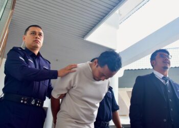 MUHAMAD Akmal Helmi Mat Sirat diiringi anggota polis selepas dihadapkan ke mahkamah atas pertuduhan mengikuti dan menjejaki bekas isteri dan membuat hantaran jelik di sosial media. - UTUSAN/ARIF HAMIZAN MISKON