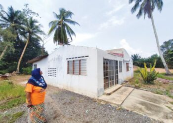 MAIMUNAH Mustafa di hadapan rumahnya yang tiada bumbung akibat diterbangkan ribut pada kejadian September tahun lalu di Kampung Telok Amboi, Kota Kuala Muda di Sungai Petani.