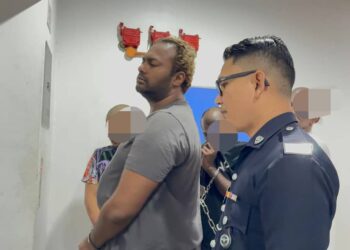 TERTUDUH (kiri) ketika dibawa ke Mahkamah Majistret George Town, Pulau Pinang hari ini atas pertuduhan melakukan pemerasan untuk menyebarkan gambar bogel kenalan lelakinya.