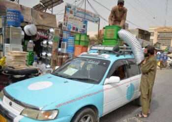 SEORANG pemandu teksi Afghanistan memasang sistem penyejuk udara buatan sendiri di atas kenderaannya di sebuah pasar di Kandahar.- AFP