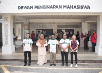 Hamizah Abdullah (dua kiri) diiringi Razali Kulim (tengah) ketika mendaftar masuk ke Universiti Sultan Azlan Shah (USAS), Perak.