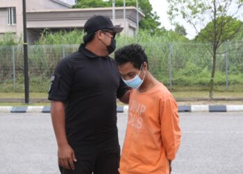TERTUDUH (kanan) semasa dibawa polis untuk menghadiri prosiding perbicaraan di Mahkamah Sesyen Kota Bharu, Kelantan hari ini. - UTUSAN/ROSALWANI CHE SOH