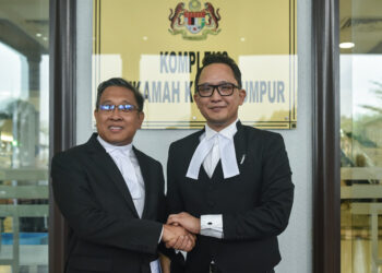 PEGUAM Mior Nor Haidir Suhaimi (kiri) dan Shahrul Fazli bersalaman selepas selesai perbicaraan kes saman fitnah antara Mahathir Mohamad dan Ahmad Zahid Hamidi di pekarangan Kompleks Mahkamah Kuala Lumpur, semalam. – UTUSAN/M. FIRDAUS M. JOHARI