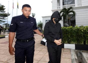 DEPUTI Superintenden Mohd. Nazri Abdul Razak (kanan) tiba di Mahkamah Tinggi Ipoh hari ini bagi prosiding kes bunuh pelajar lelaki tingkatan lima, dua tahun lalu. - UTUSAN/ASLIZA MUSA
