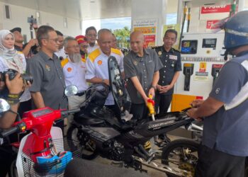 ARMIZAN Mohd. Ali (dua dari kanan) membantu mengisi minyak petrol percuma kepada orang ramai pada Majlis Perasmian Stesen Minyak Shell Panchor, Kota Bharu,Kelantan. - UTUSAN/ROSMIZAN RESDI