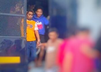 NIK Mohd. Helmy Raja Sulong (baju oren) semasa menghadiri prosiding perbicaraan di Mahkamah Sesyen Kota Bharu, Kelantan.