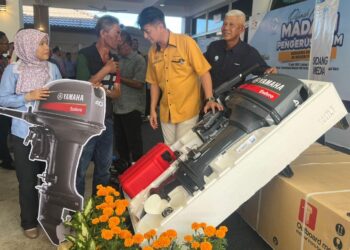 MUHAMMAD Faiz Fadzil (dua dari kanan) beramah mesra dengan salah seorang penerima bantuan enjin sangkut pada Program Rahmah Mesra Madani Pengerusi LKIM Bersama Nelayan di Pusat Transformasi Nelayan PNK Perlis Selatan, Kuala Sungai Baru, Perlis, hari ini. -UTUSAN/ASYRAF MUHAMMAD