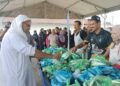 SYED Abu Hussin Hafiz Syed Abdul Fasal (kiri) mengagihkan ikan percuma kepada penduduk di Pusat Khidmat beliau di Bukit Gantang hari ini. - UTUSAN/WAT KAMAL ABAS