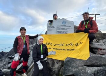 LORENICA Frenila Masundim (depan) bersama tiga guru lain daripada Sekolah Kebangsaan K9 Beluran, Sabah menunjukkan gegantung  bertulis Mari Belajar Tulisan Jawi  di Gunung Kinabalu.