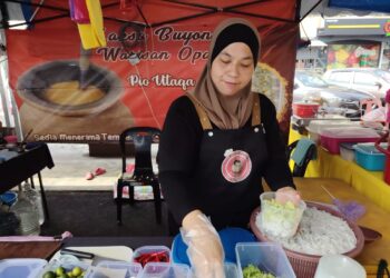 MARZURENA Zulkifli menyediakan Laksa Penang yang dijual  di Uptown D Kukup di Pekan Kukup Laut, di Pontian, disini, hari ini.