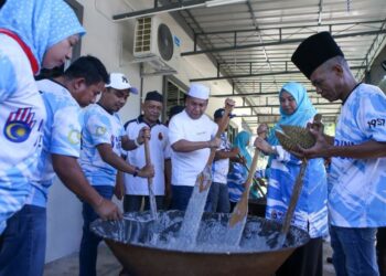 MOHAMAD Rudzi Samsudin (tengah) bergotong-royong mengacau bubur asyura yang dimasukkan isi durian premium termasuk Musang King sebagai bahan utama di Kampung Lubuk Ayer, Ayer Hitam di Jerlun, Kedah.– UTUSAN/SHAHIR NOORDIN