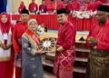 ASYRAF Wajdi Dusuki menyampaikan anugerah khas kepada Rokiah Hanafiah pada perasmian Mesyuarat Perwakilan UMNO Kubang Pasu di MRSM Kubang Pasu di Jitra, hari ini.