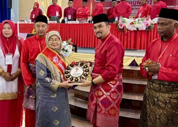 ASYRAF Wajdi Dusuki menyampaikan anugerah khas kepada Rokiah Hanafiah pada perasmian Mesyuarat Perwakilan UMNO Kubang Pasu di MRSM Kubang Pasu di Jitra, hari ini.