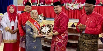ASYRAF Wajdi Dusuki menyampaikan anugerah khas kepada Rokiah Hanafiah pada perasmian Mesyuarat Perwakilan UMNO Kubang Pasu di MRSM Kubang Pasu di Jitra, hari ini.