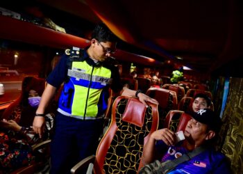 ZAMRI Samion (tengah) memantau pemakaian  tali pinggang keledar penumpang bas dalam Op Pemakaian Tali Pinggang Keledar Bas Ekspres dan Persiaran di Chendering, Kuala Terengganu, Terengganu. - UTUSAN/PUQTRA HAIRRY