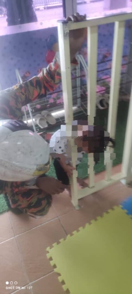 Kepala budak perempuan tersepit di penghadang besi