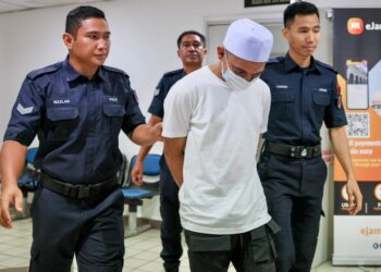 ABDUL Rahman Mohamad Hussain (tengah) dibawa keluar dari Mahkamah Majistret Kuala Terengganu, Terengganu hari ini. -UTUSAN/PUQTRA HAIRRY