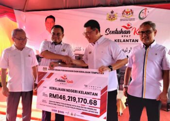 NGA Kor Ming (dua dari kanan) menyerahkan replika cek berjumlah RM146.22 juta kepada Pengerusi Jawatankuasa Kerajaan Tempatan, Perumahan, Kesihatan dan Alam Sekitar Kelantan, Hilmi Abdullah (dua dari kiri) pada Program Sentuhan Kasih 3.0 di Kampung Penambang, Kota Bharu, Kelantan hari ini. - UTUSAN/MUSTAQIM MOHAMED