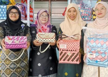 NURUL Syafiqah Isham (kanan)  dan Siti Furiza Md. Baki (dua dari kanan) dan rakan menunjukkan kraftangan dihasilkan di Kampung Baru Batu 4 Tapah Road di Tapah. – UTUSAN/MEGAT LUTFI MEGAT RAHIM