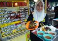 NURATIKAH Surahman   menunjukkan antara menu sate yang terdapat 
di kedai mereka di Taman Krubong Jaya. 
– mingguan/ARIF HAMIZAN MISKON