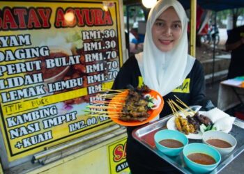 NURATIKAH Surahman   menunjukkan antara menu sate yang terdapat 
di kedai mereka di Taman Krubong Jaya. 
– mingguan/ARIF HAMIZAN MISKON