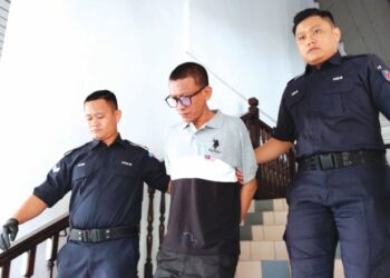 MOHD. Shahrizan Othman diiringi anggota polis selepas dihadapkan ke Mahkamah Majistret Ayer Keroh, Melaka atas pertuduhan menghisap syabu. – UTUSAN/ MUHAMMAD SHAHIZAM TAZALI