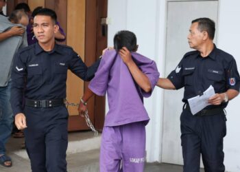 SEORANG pemandu bot (tengah) dibawa keluar dari Mahkamah Majistret Besut, Terengganu  selepas proses sambung reman diperoleh atas kesalahan berkaitan dadah. - UTUSAN / WAN ZURATIKAH IFFAH WAN ZULKIFLI