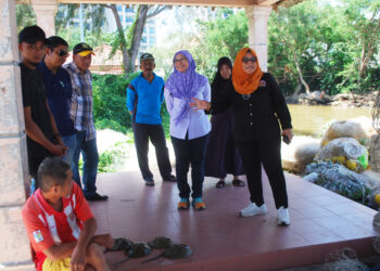 TUMINAH Kadi dan Sharmila Mohamed Salleh bersama nelayan Sungai Lereh meninjau tapak penternakan ketam nipah moden di Jeti Nelayan Sungai Lereh. UTUSAN/AMRAN MULUP