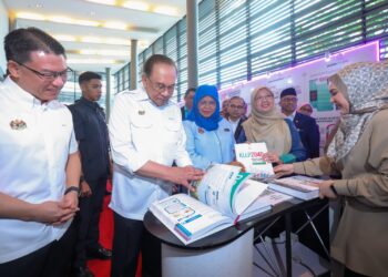 PERDANA Menteri, Datuk Seri Anwar Ibrahim membelek buku Pelan Tempatan Kuala Lumpur (PTKL
2040) ketika melawat reruai pameran pada majlis peluncuran pelan tempatan itu di Kuala Lumpur
baru-baru ini. – UTUSAN/MUHAMAD IQBAL ROSLI