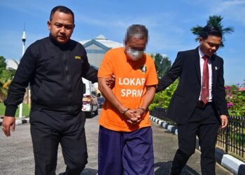 SEORANG penjawat awam dibawa keluar dari Mahkamah Majistret Kuala Terengganu setelah direman lima hari bagi membantu siasatan berhubung kes salah guna kuasa melibatkan beberapa permohonan tanah kerajaan. - UTUSAN/PUQTRA HAIRRY