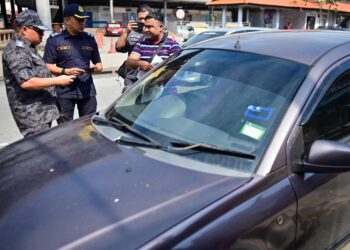 ANGGOTA Jabatan Imigresen Malaysia dan Jabatan Pengangkutan Jalan (JPJ) menahan seorang lelaki warga Rohingya kerana memandu kenderaan tanpa lesen dalam Op Belanja, Mahir dan Minyak di sekitar bandar Kuala Terengganu, Terengganu. - UTUSAN/PUQTRA HAIRRY