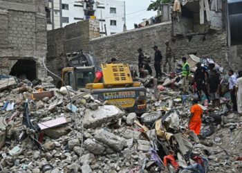 PASUKAN penyelamat menjalankan operasi mencari mangsa yang terperangkap dalam runtuhan bangunan lima tingkat di Karachi, semalam.- AFP