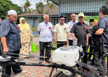 MOHAMAD Sabu (dua dari kanan) melihat dron untuk pertanian yang dipamerkan sempena Pesta Durian 2025 anjuran Persatuan Pelabur Pertanian Gua Musang (PPPGM) di Dewan Perdana, Gua Musang, Kelantan. UTUSAN/AIMUNI TUAN LAH
