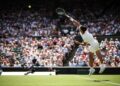 Pemain Sepanyol, Carlos Alcaraz memukul bola servis kepada Fabio Fognini dalam saingan tenis Wimbledon di gelanggang kelab The All England Lawn Tennis and Croquet, London, semalam. - AFP
