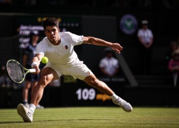 Carlos Alcaraz membalas pukulan Andrey Rublev dalam saingan tenis Wimbledon di gelanggang kelab All England Lawn Tennis and Croquet Club, London, semalam. AFP