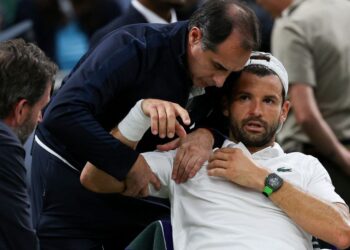 Pemain tenis Bulgaria, Grigor Dimitrov menerima rawatan daripada pasukan perubatan selepas mengalami keederaan semasa menentang lawan dari Itai, Jannik Sinner dalam pusingan keempat Kejohanan Wimbledon di Kelab All England Lawn Tennis and Croquet, London, semalam. - AFP