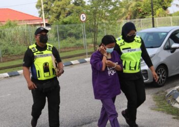 ANGGOTA  polis membawa Siti Anis Phua Abdullah (tengah) untuk didakwa atas pertuduhan mencederakan suaminya menggunakan pisau di Mahkamah Sesyen Kota Bharu, Kelantan hari ini. - UTUSAN/ROSALWANI CHE SOH