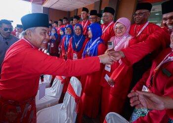 AHMAD Zahid Hamidi bersalam dengan perwakilan pada Mesyuarat Perwakilan UMNO Bahagian Lumut hari ini. - UTUSAN