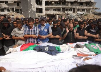 PENDUDUK Palestin menunaikan solat jenazah bagi wartawan dan petugas perubatan yang terkorban akibat bedilan udara tentera Israel di Gaza City. – AFP