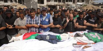 PENDUDUK Palestin menunaikan solat jenazah bagi wartawan dan petugas perubatan yang terkorban akibat bedilan udara tentera Israel di Gaza City. – AFP