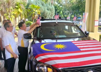 CHOW Kon Yeow meletakkan Jalur Gemilang pada kenderaan pacuan empat roda sempena pelancaran Bulan Kebangsaan dan Kibar Jalur Gemilang peringkat Pulau Pinang di George Town, Pulau Pinang, hari ini.
