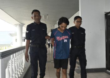 AMIRUL Hamry Hambalyi Azahari (tengah) dibawa anggota polis bagi dihadapkan ke Mahkamah Sesyen Ayer Keroh, Melaka hari ini atas pertuduhan merompak menggunakan pisau pemotong daging bulan lalu.-UTUSAN/MUHAMMAD SHAHIZAM TAZALI.