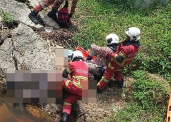 ANGGOTA bomba membantu mangsa yang terlibat kemalangan di Meru Raya, Ipoh hari ini. - UTUSAN